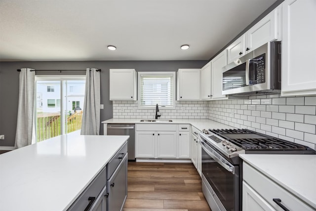 610 NE Whitetail Dr, Ankeny, IA 50021 - kitchen with stainless steel appliances, dark wood-style flooring, light countertops, white cabinets, and recessed lighting