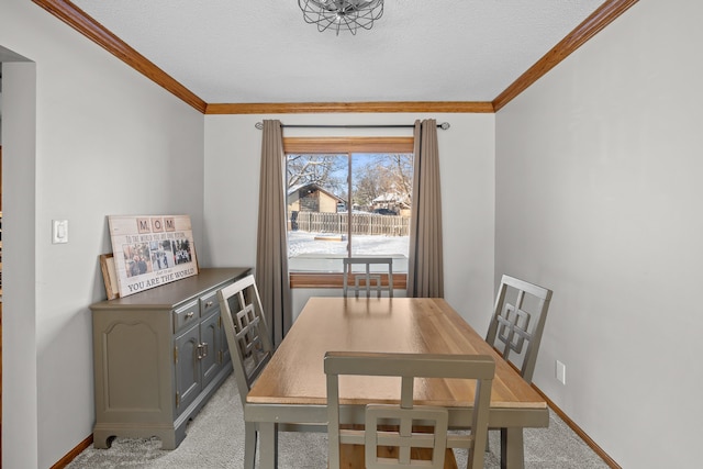 carpeted dining space with ornamental molding and a textured ceiling