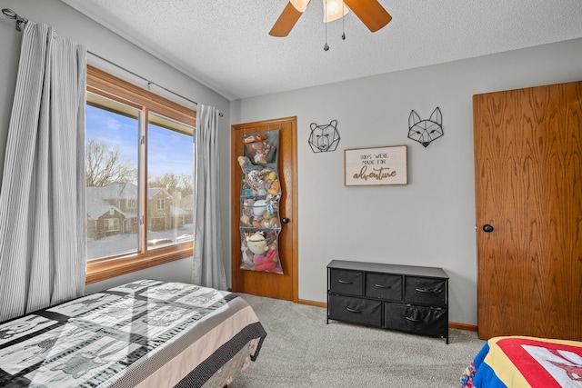 bedroom featuring ceiling fan, a textured ceiling, and carpet