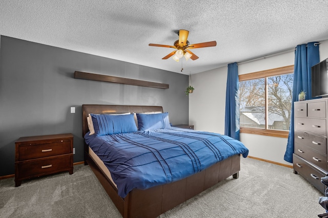 bedroom with ceiling fan, carpet flooring, and a textured ceiling