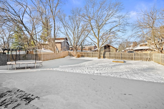 yard layered in snow featuring a trampoline