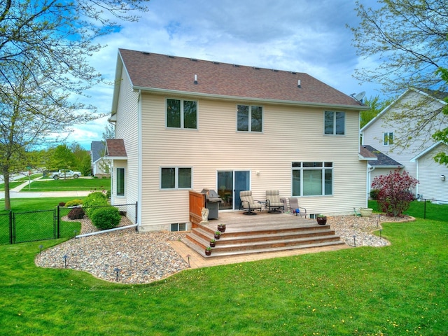 rear view of property featuring a wooden deck and a yard