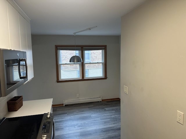 dining area featuring dark wood-style floors, a baseboard radiator, and baseboards