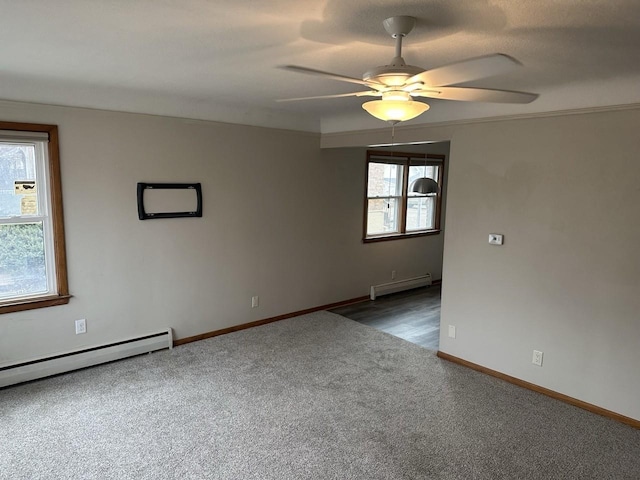 carpeted spare room featuring baseboard heating, a baseboard radiator, a ceiling fan, and baseboards