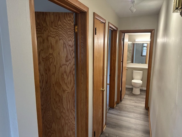 hall with light wood-style flooring and baseboards