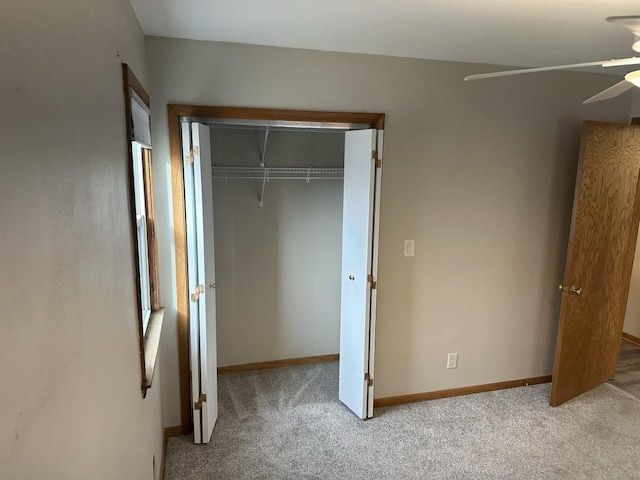 unfurnished bedroom with a closet, carpet flooring, and baseboards