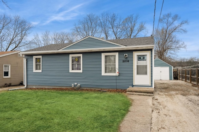 view of front of house with fence, a front lawn, and roof with shingles