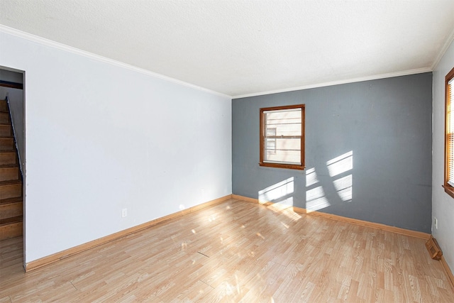 unfurnished room with crown molding, a textured ceiling, and light hardwood / wood-style floors