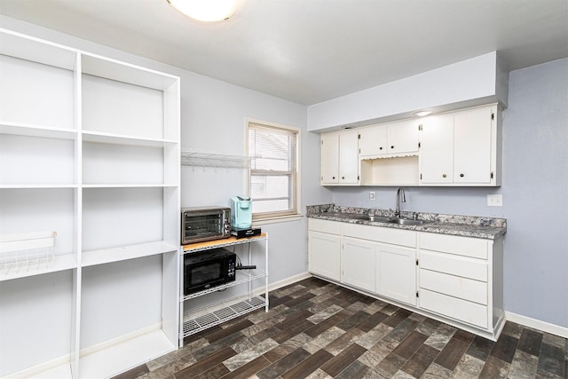 kitchen with white cabinetry, dark wood-type flooring, and sink