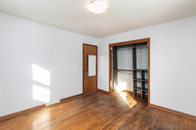 unfurnished bedroom featuring dark hardwood / wood-style floors and a closet