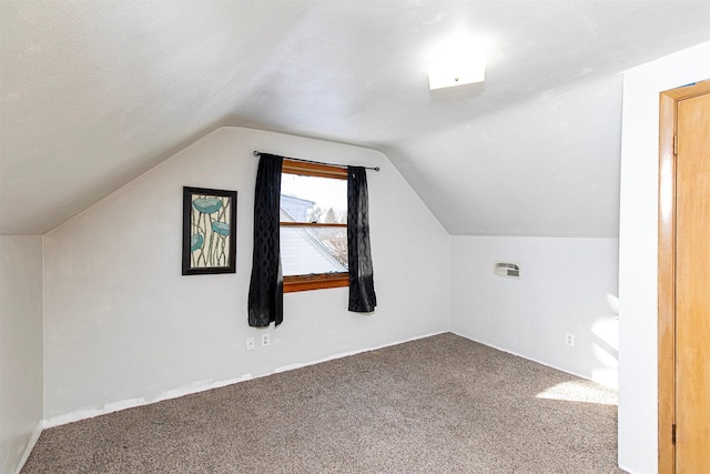 bonus room with vaulted ceiling and carpet flooring