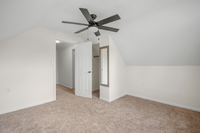 bonus room with lofted ceiling and light carpet