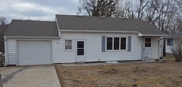 ranch-style house with entry steps, concrete driveway, roof with shingles, and an attached garage