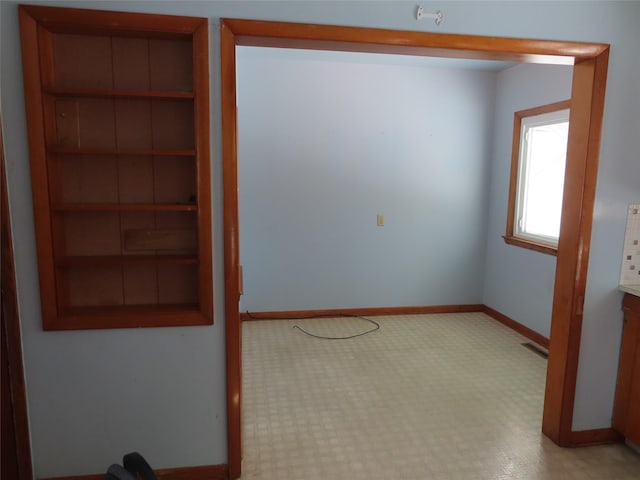 empty room featuring baseboards and visible vents