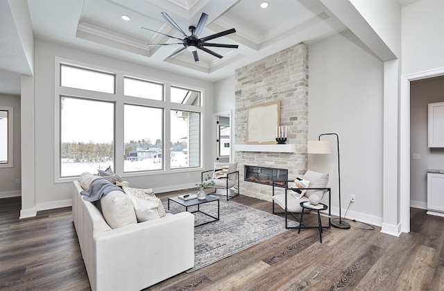 living area with coffered ceiling, dark wood-style flooring, and a stone fireplace