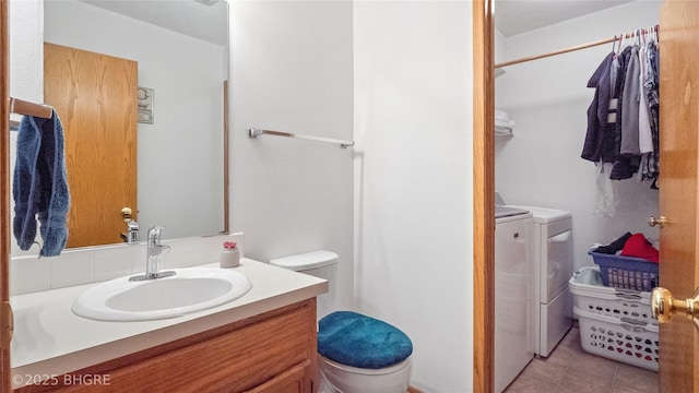 bathroom with tile patterned flooring, vanity, independent washer and dryer, and toilet