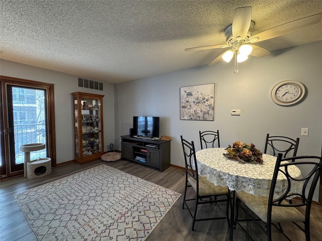 dining room featuring dark hardwood / wood-style flooring, ceiling fan, and a textured ceiling