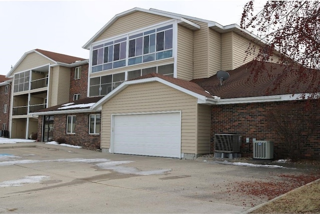 view of front facade with cooling unit and a garage