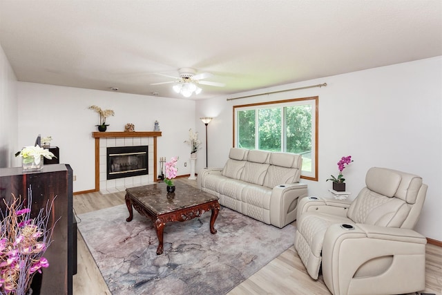 3015 Deerpath Ct, Des Moines, IA 50320 - living area with light wood-type flooring, a ceiling fan, and a tile fireplace