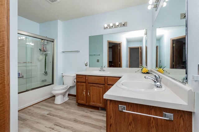 3015 Deerpath Ct, Des Moines, IA 50320 - full bathroom featuring double vanity, enclosed tub / shower combo, and wood finished floors