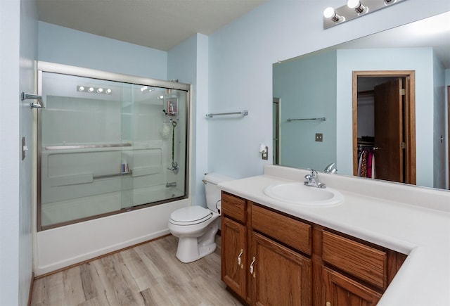3015 Deerpath Ct, Des Moines, IA 50320 - full bathroom featuring vanity, shower / bath combination with glass door, wood finished floors, and a spacious closet