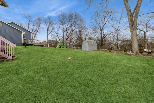 3015 Deerpath Ct, Des Moines, IA 50320 - view of grassy yard featuring a shed, a wooden deck, and a playground