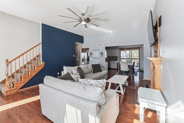 living area featuring stairway, visible vents, a ceiling fan, and wood finished floors