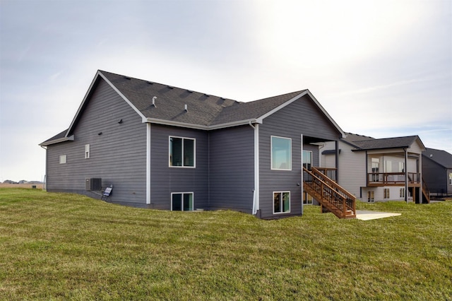 rear view of house featuring a yard, a deck, and central air condition unit