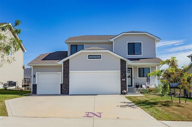 view of front property featuring a garage, a front yard, and central air condition unit