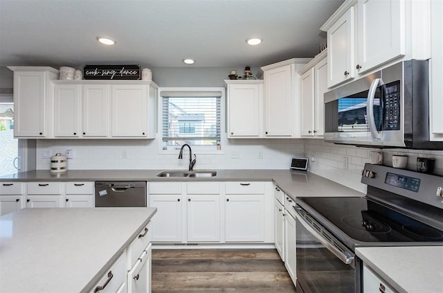 kitchen featuring sink, dark wood-type flooring, appliances with stainless steel finishes, tasteful backsplash, and white cabinets