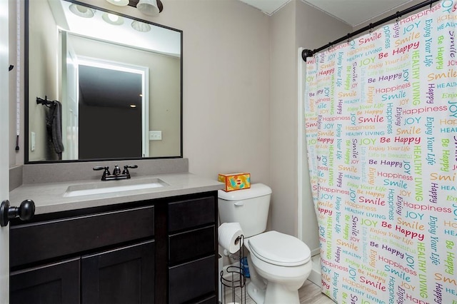 bathroom featuring vanity, toilet, and walk in shower