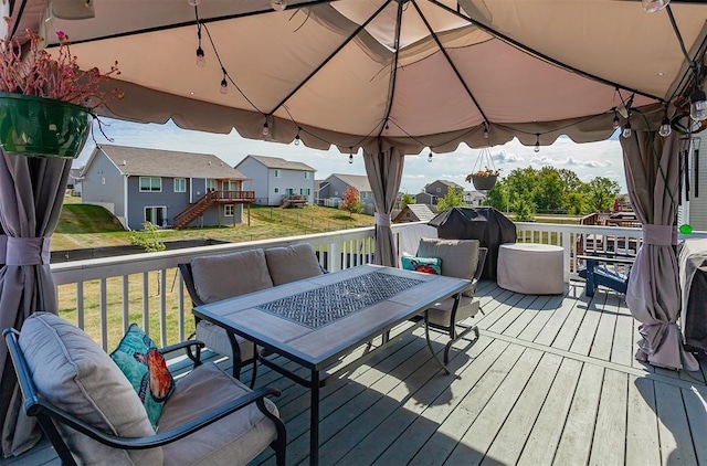 wooden deck featuring a gazebo and a lawn