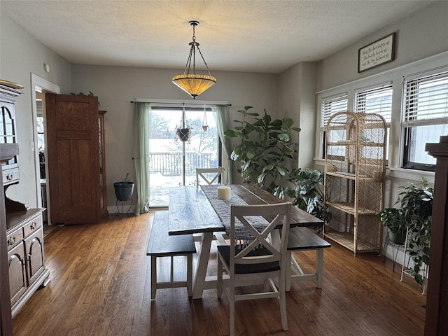 dining space with dark wood-type flooring and a textured ceiling