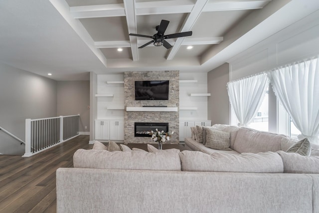 living room featuring dark wood-type flooring, ceiling fan, coffered ceiling, a fireplace, and beamed ceiling