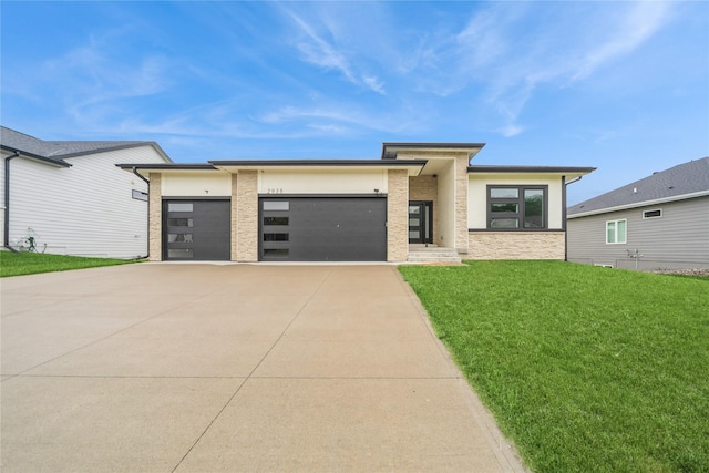 2938 NE Brentwood Cir, Grimes, IA 50111 - prairie-style house featuring an attached garage, driveway, a front lawn, and stone siding