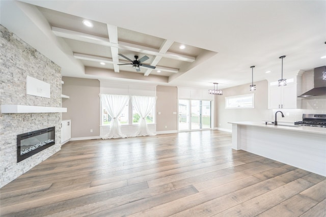 2938 NE Brentwood Cir, Grimes, IA 50111 - unfurnished living room featuring coffered ceiling, light wood-style flooring, recessed lighting, a fireplace, and a ceiling fan