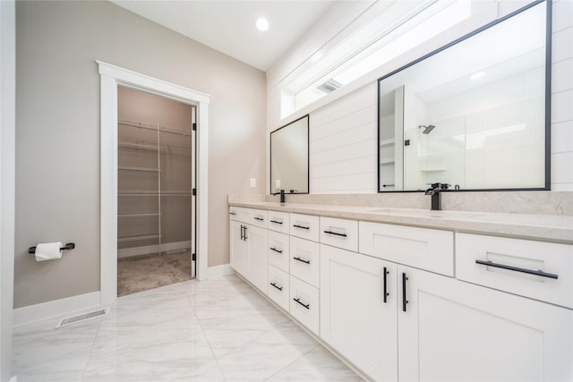 2938 NE Brentwood Cir, Grimes, IA 50111 - bathroom with marble finish floors, double vanity, a spacious closet, a tile shower, and recessed lighting