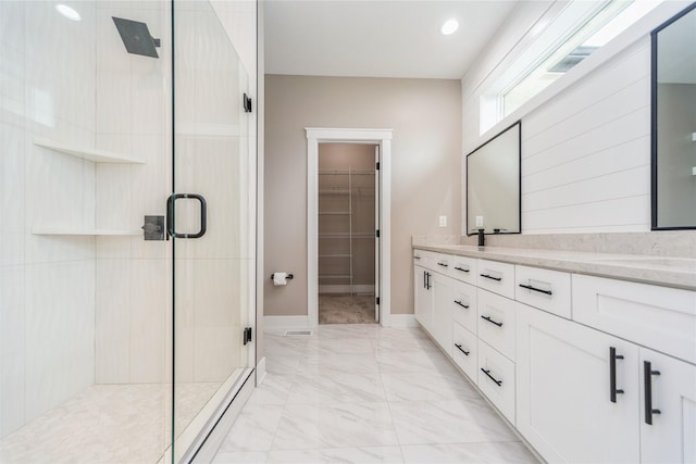 2938 NE Brentwood Cir, Grimes, IA 50111 - full bathroom with a shower stall, double vanity, a walk in closet, marble look tile flooring, and recessed lighting