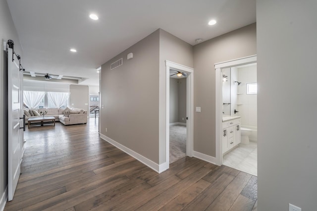 2938 NE Brentwood Cir, Grimes, IA 50111 - hall featuring hardwood / wood-style flooring, recessed lighting, and a barn door