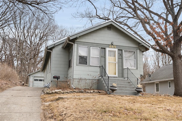 bungalow-style house with a garage and an outbuilding