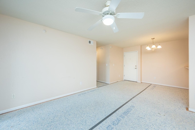 empty room with ceiling fan with notable chandelier