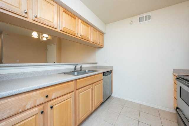 kitchen with stainless steel appliances, sink, light tile patterned floors, and light brown cabinetry