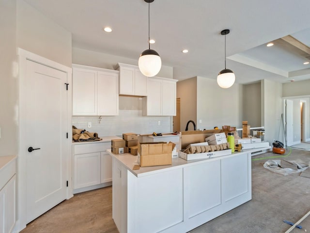 kitchen featuring hanging light fixtures, backsplash, a center island, and white cabinets