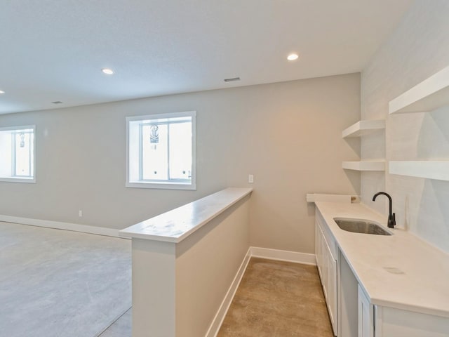 bar featuring white cabinetry and sink