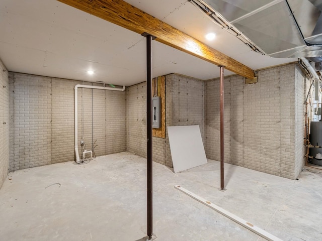 basement with brick wall and electric panel