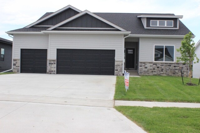 4651 180th St, Urbandale, IA 50323 - craftsman-style house with an attached garage, stone siding, a front lawn, concrete driveway, and roof with shingles