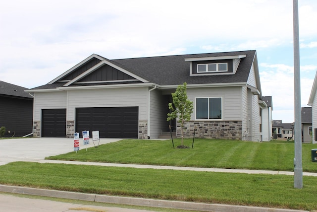 4651 180th St, Urbandale, IA 50323 - craftsman inspired home with stone siding, a garage, a front yard, driveway, and board and batten siding