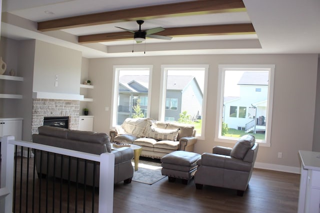 4651 180th St, Urbandale, IA 50323 - living area with dark wood finished floors, a ceiling fan, beamed ceiling, and a stone fireplace