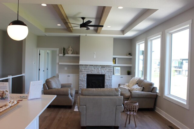 4651 180th St, Urbandale, IA 50323 - living area with dark wood finished floors, a ceiling fan, a stone fireplace, built in features, and recessed lighting