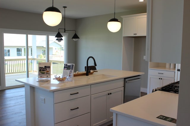 4651 180th St, Urbandale, IA 50323 - kitchen featuring stainless steel dishwasher, a center island with sink, white cabinetry, light countertops, and pendant lighting